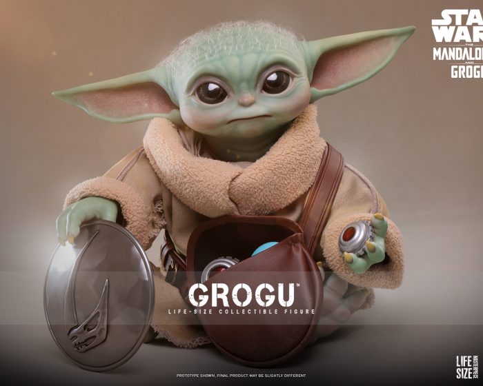 A highly detailed, 1:1 scale Grogu Life-Size Collectible Figure by Hot Toys, featuring a realistic head sculpt, fabric robes, and a leather-like pouch filled with accessories like a magnetic rondel and grav charges.