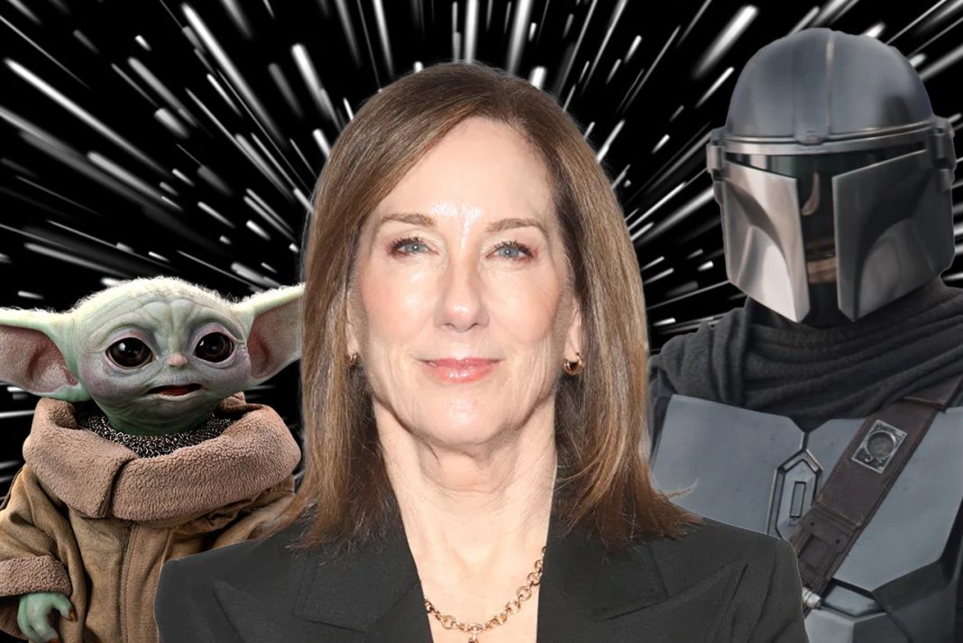 A cinematic shot featuring a Mandalorian, the small, green character Grogu, and Kathleen Kennedy.