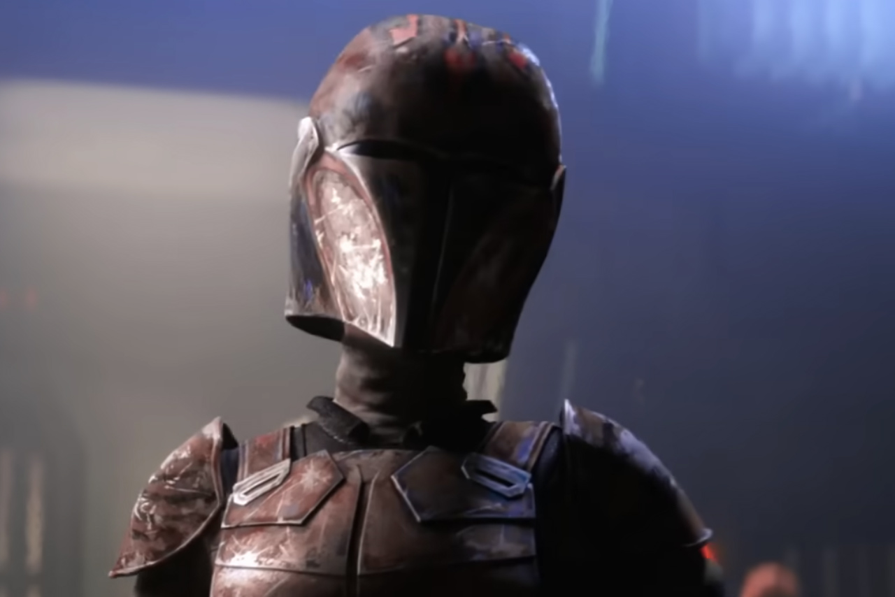 A close-up of a Mandalorian warrior wearing weathered, dark red and black armor with a customized helmet featuring Maul-inspired horn patterns and a cracked visor.