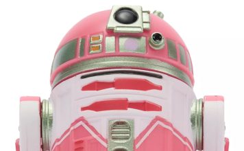 Close-up front view of the QT-KT Droid Factory action figure, featuring a vibrant pink and white dome with silver metallic accents and a black primary photoreceptor lens.