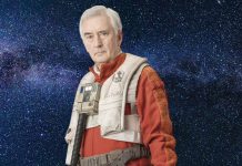 Star Wars: Star Pilots – Wedge Antilles Returns in New Action-Packed Story This Fall A portrait of an older Wedge Antilles (Denis Lawson) in a red Resistance flight suit and white life vest against a star-filled space background.