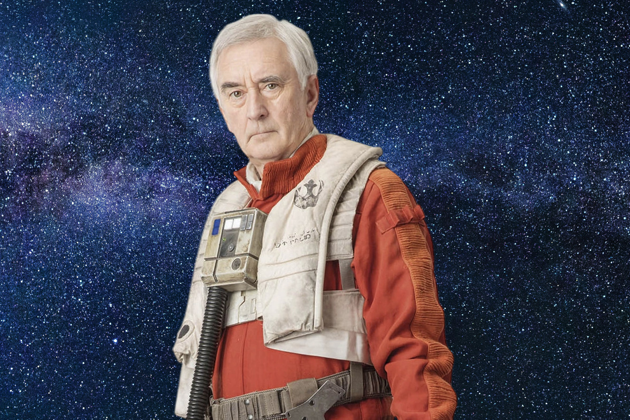 A portrait of an older Wedge Antilles (Denis Lawson) in a red Resistance flight suit and white life vest against a star-filled space background.