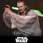 Hot Toys Qui-Gon Jinn 1/6th scale collectible figure wearing a gray poncho and wielding a green lightsaber.