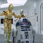 C-3PO and R2-D2 standing in a white Tantive IV hallway from Star Wars: A New Hope.